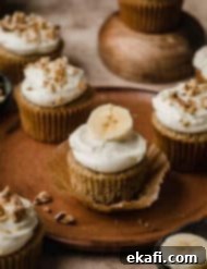 Συνταγή για Κάπκεϊκς Μπανάνας 8 Cupcakes μπανάνας με γλάσο τυριού κρέμας και φέτα μπανάνας, σε ένα καφέ πιάτο.