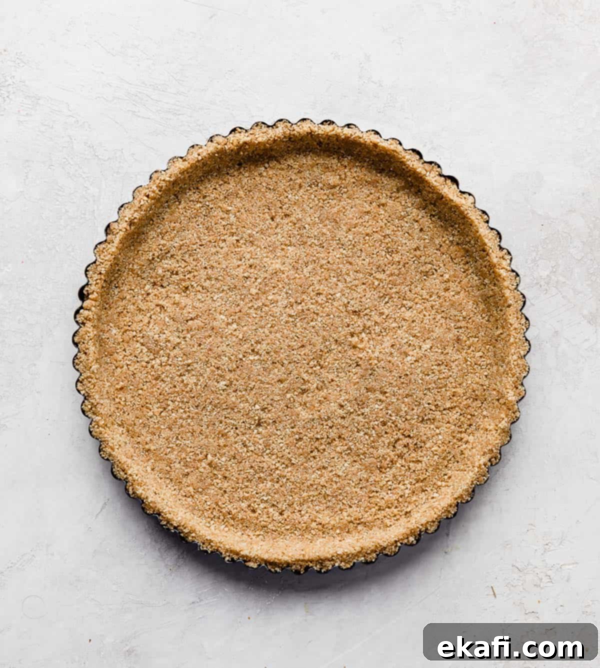 Μια βάση από graham cracker σε ένα ταψί για τάρτα.