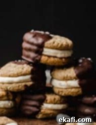 Μπισκότα Σάντουιτς Σ'μόρες 9 Μπισκότα S'mores Σάντουιτς βουτηγμένα μέχρι τη μέση σε λιωμένη σοκολάτα σε σκούρο μαύρο φόντο.