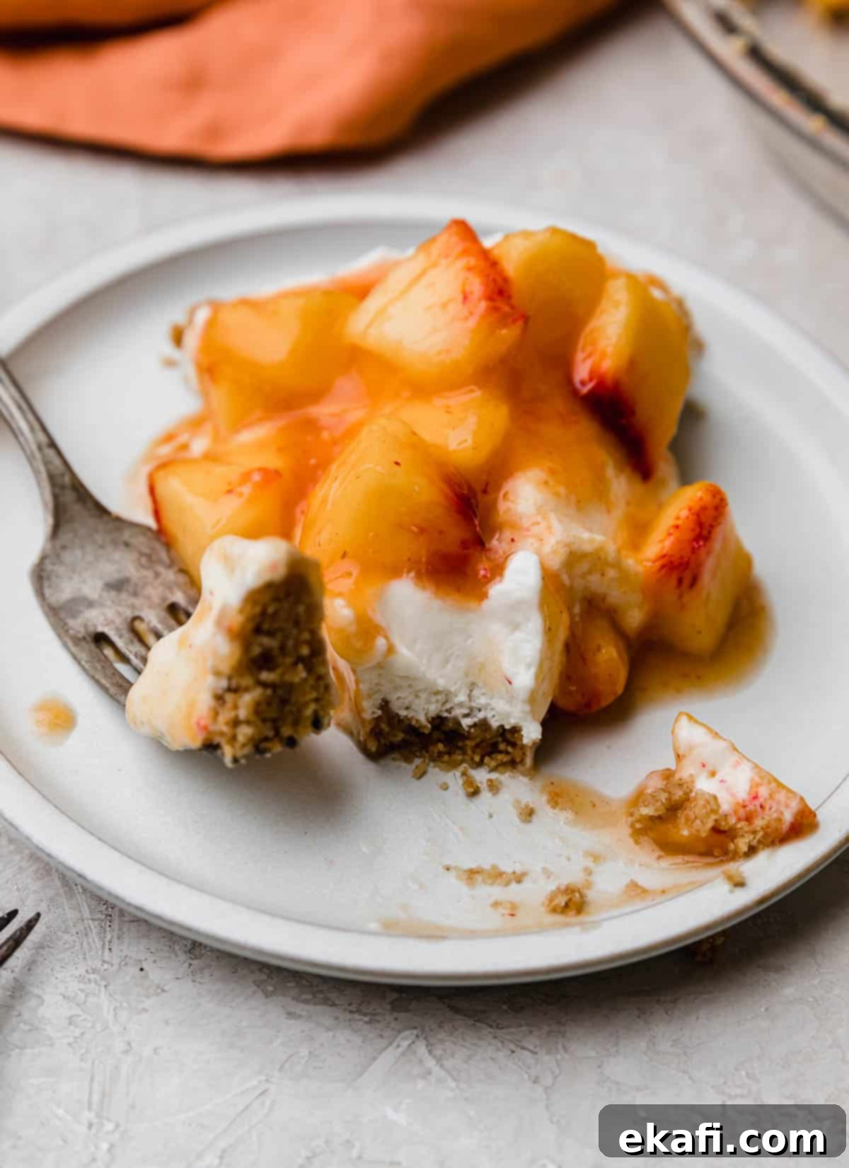 **Κρεμόπιτα Ροδάκινου** 8 Μια φέτα Peach Cream Pie σε λευκό πιάτο με ένα πιρούνι να κόβει μια μπουκιά από την άκρη της φέτας.