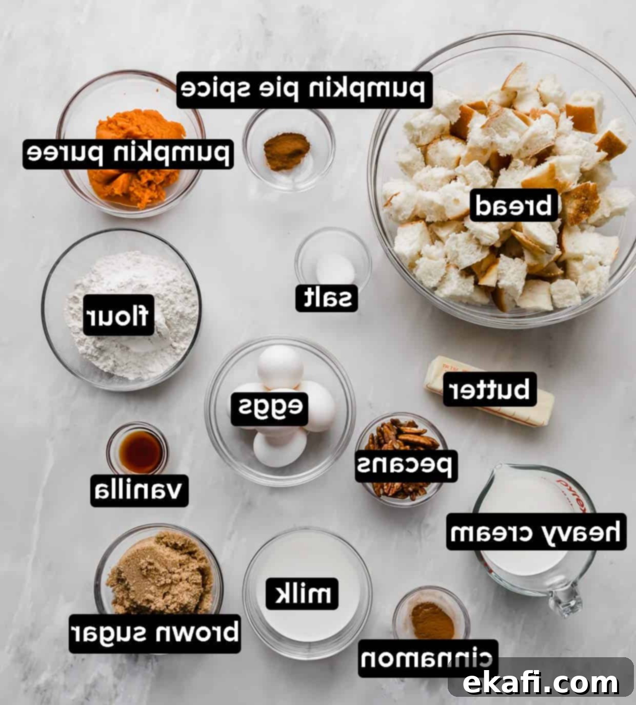 Πουτίγκα αυγόψωμου κολοκύθας 4 Υλικά για Κασερόλα Γαλλικής Φρυγανιάς Κολοκύθας σε γυάλινα μπολ σε μαρμάρινο τραπέζι.