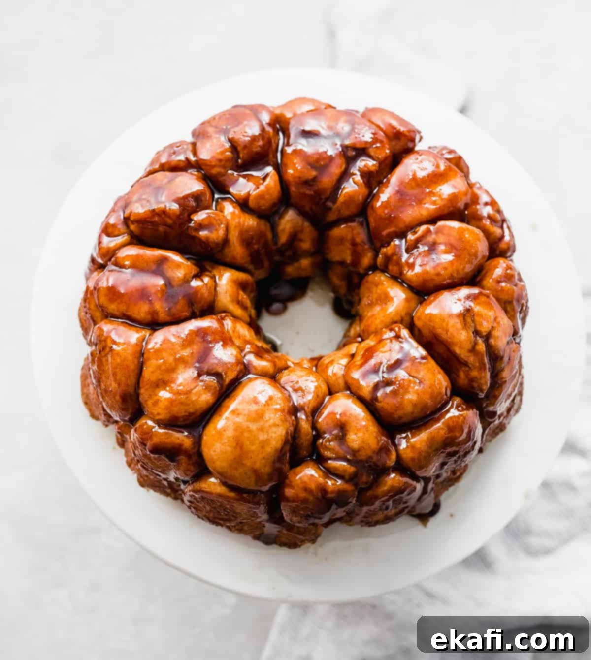 Μάνκι Μπρεντ 9 Ένα χρυσαφένιο ψημένο Monkey Bread φτιαγμένο σε φόρμα Bundt, αναποδογυρισμένο σε λευκή πιατέλα.