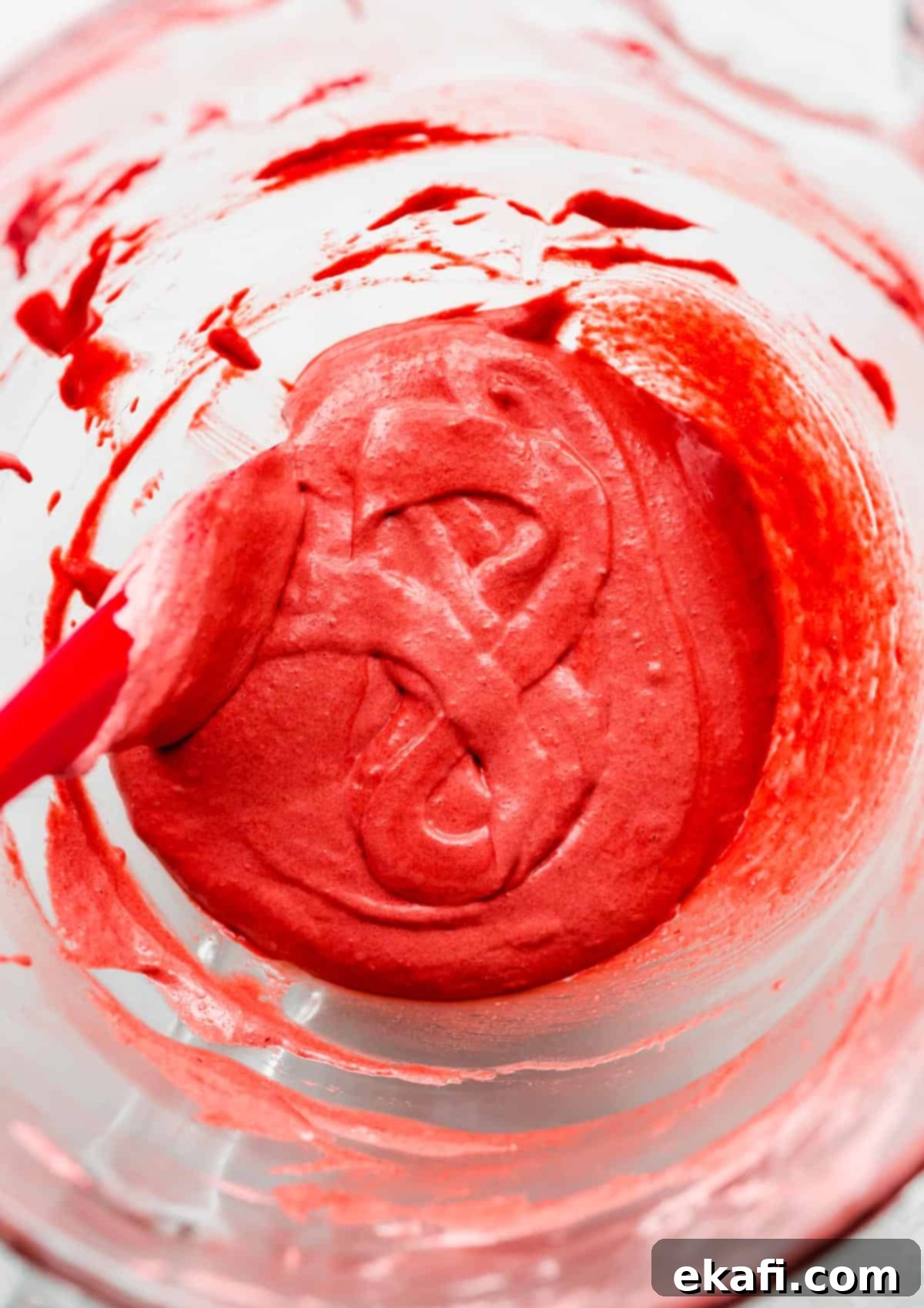 Μακαρόν Κόκκινο Βελούδο 5 A Red Velvet Macaron batter forming a figure "8" in a glass bowl.