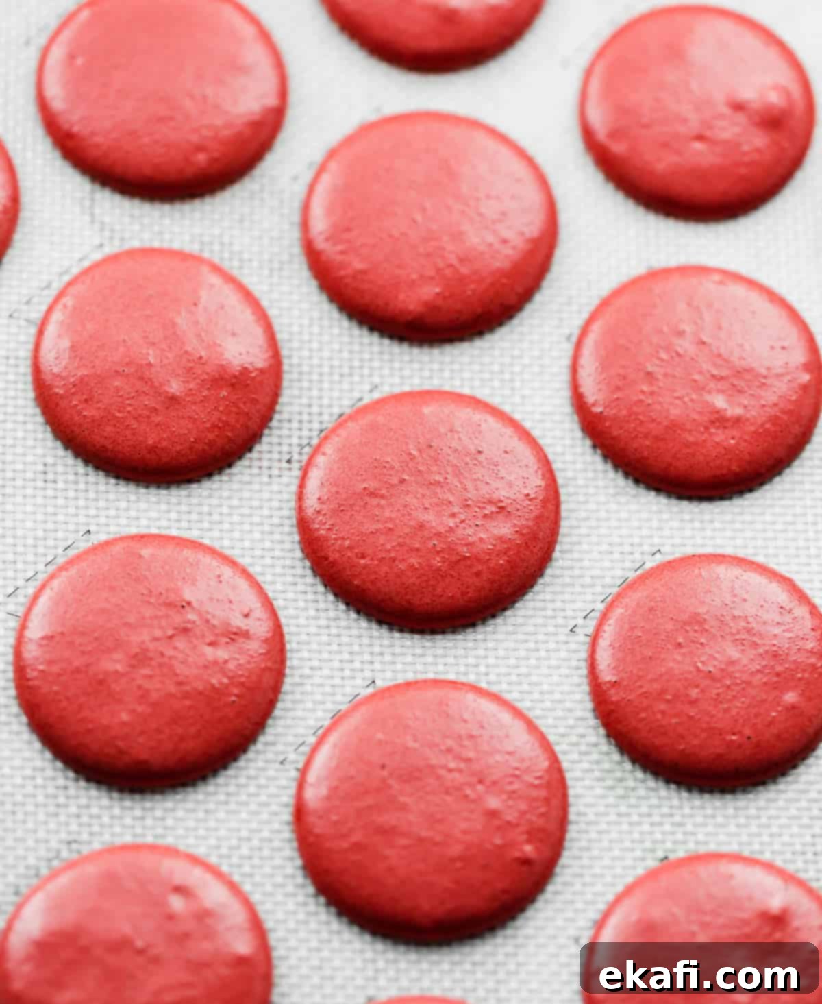 Μακαρόν Κόκκινο Βελούδο 6 Red Velvet Macaron batter piped into circles on a baking sheet.