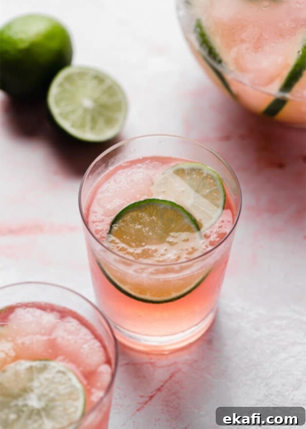 Ένα ποτήρι Limeade Slush Punch με 2 φέτες λάιμ μέσα στο ποτήρι, έτοιμο να το απολαύσετε.