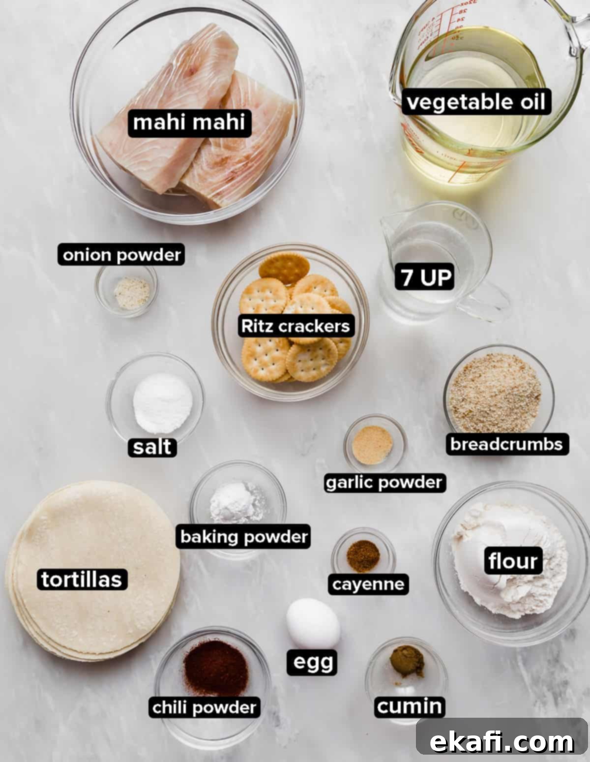Crispy Fish Taco Bliss 4 Authentic Baja Fish Taco ingredients, including fresh fish, various spices, crackers, and soft drinks, neatly arranged on a marble background.