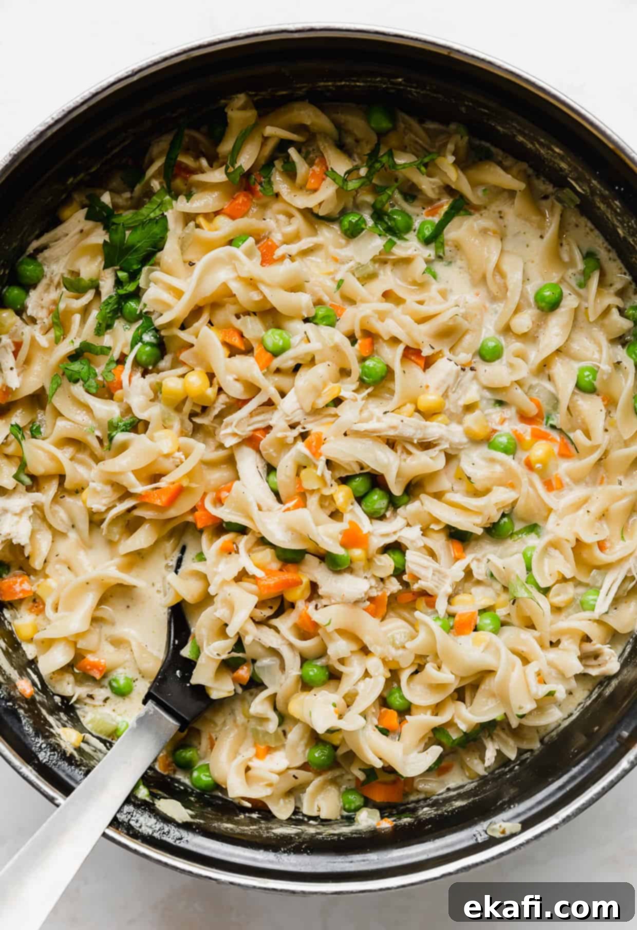 Creamy Chicken Pot Pie Noodles 6 A close up photo of egg noodle pot pie pasta in a black pot.