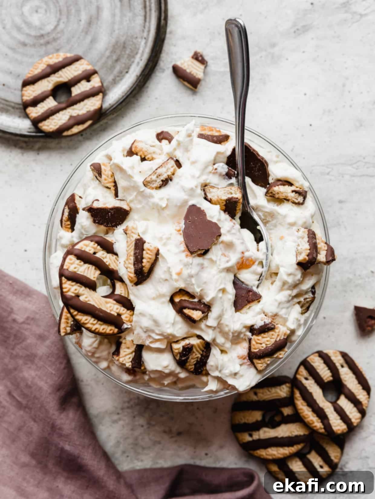 Σαλάτα Μπισκότων 2 Ένα μεγάλο μπολ γεμάτο Cookie Salad σε γκρι φόντο, περιτριγυρισμένο από μπισκότα με ρίγες σοκολάτας.