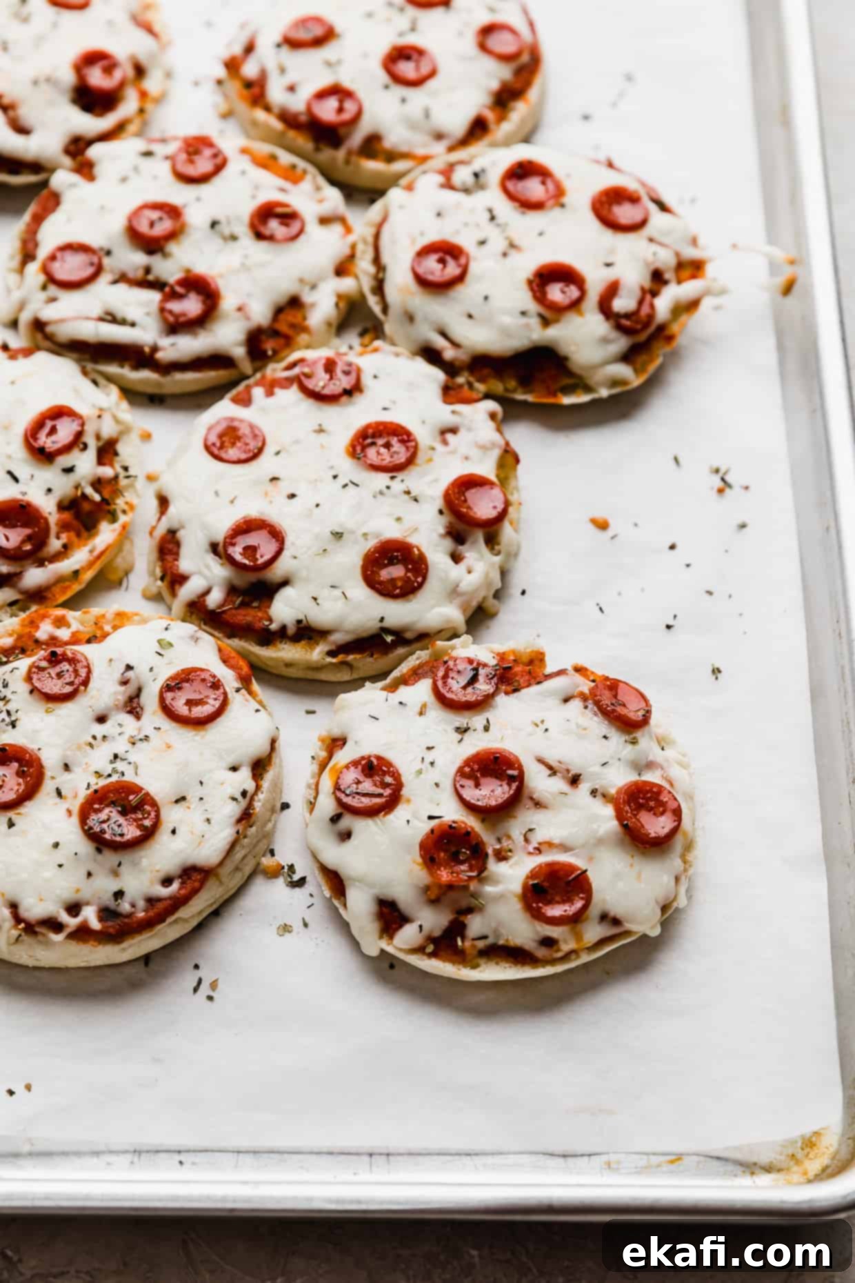Πίτσες με Αγγλικά Μάφιν 9 Ψητές πίτσες English Muffin με μίνι πεπερόνι σε λευκό ταψί στρωμένο με αντικολλητικό χαρτί.
