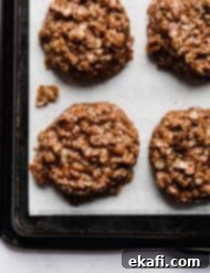 Άψητα Μπισκότα για Λίγους 14 Ένα σοκολατένιο cookie βρώμης φυστικοβούτυρου χωρίς ψήσιμο σε λευκό αντικολλητικό χαρτί.