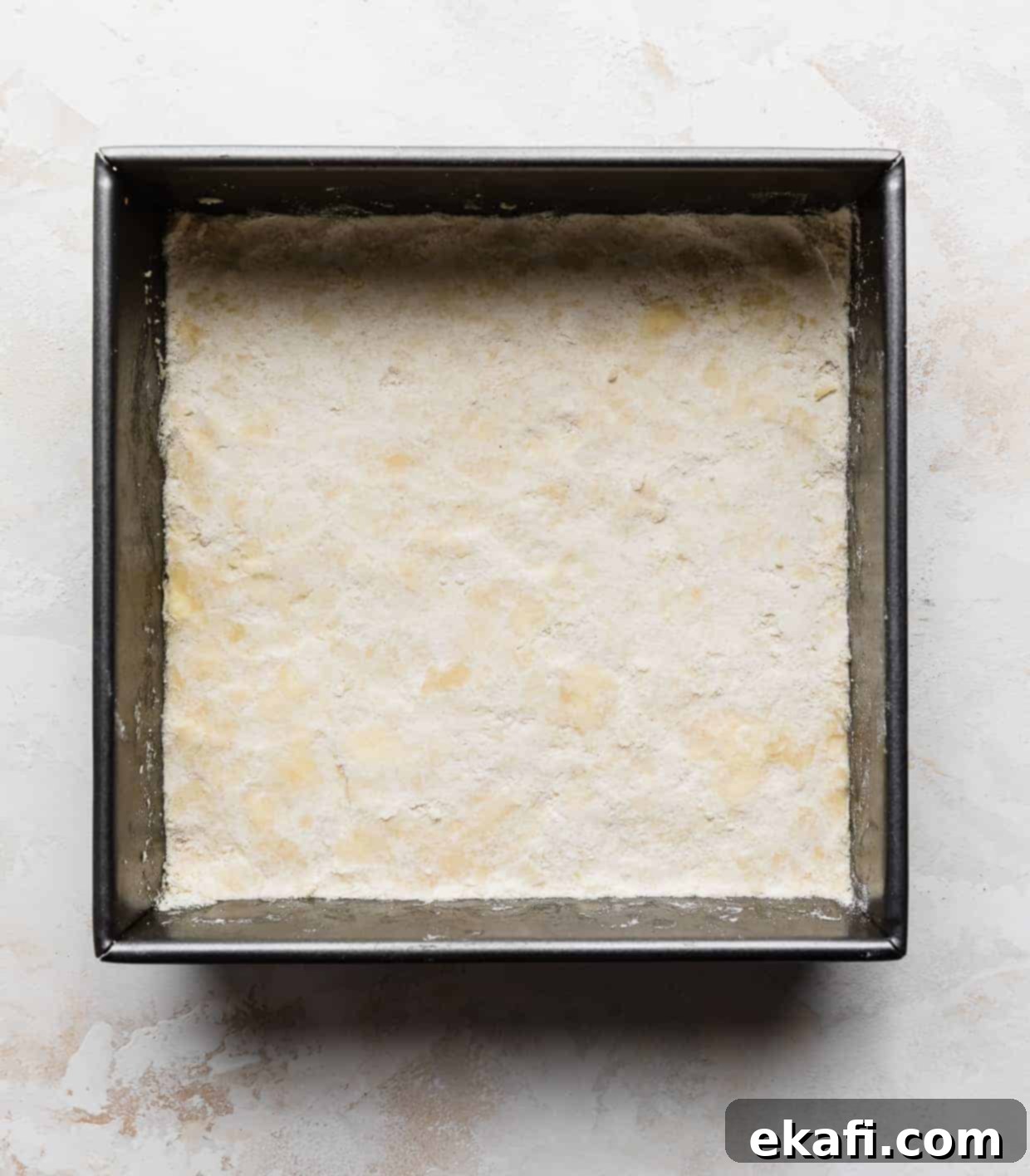 Irresistible Old Fashioned Lemon Squares 4 A square baking pan with a perfectly pressed layer of sweetened shortbread crust, ready for the filling.