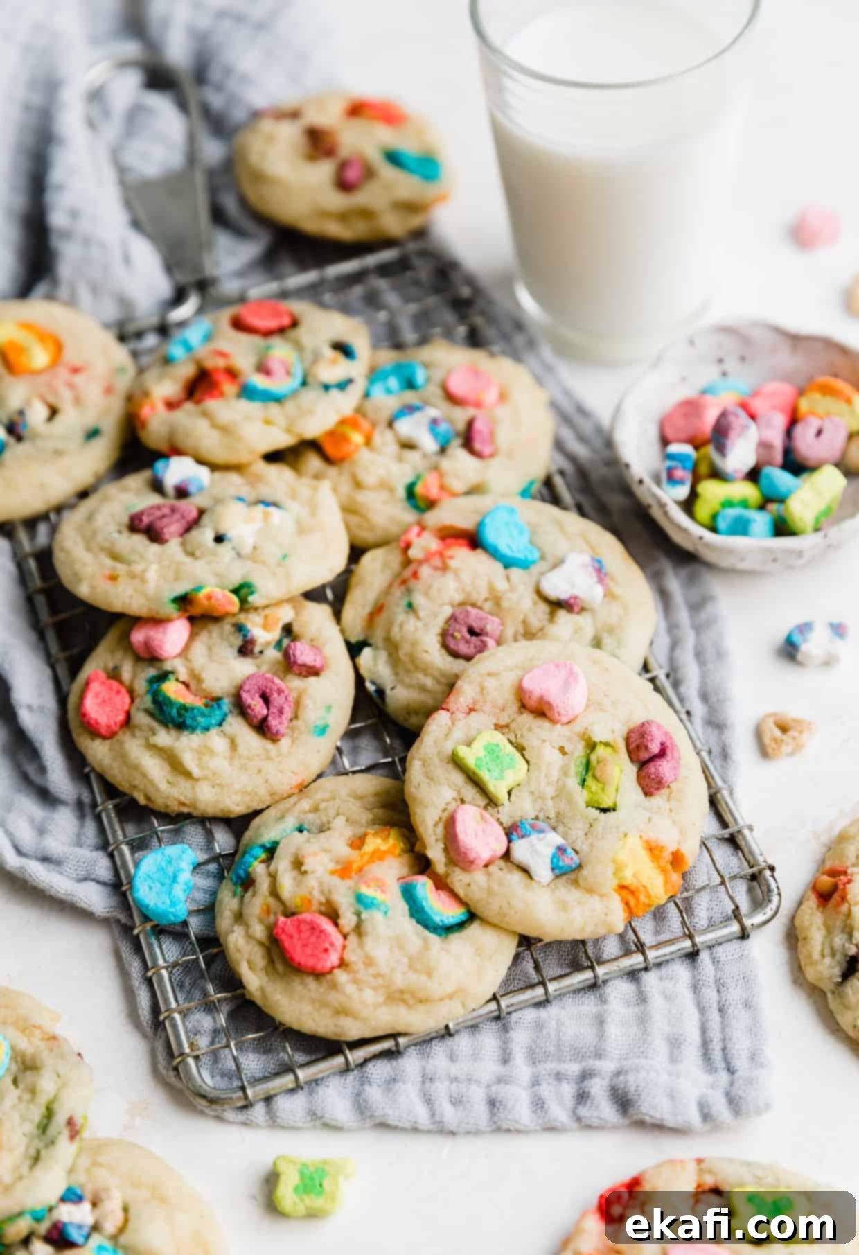 Magic Lucky Charms Cookies 2 Several Lucky Charms marshmallow-loaded sugar cookies on a wire rack against a gray napkin. These vibrant, soft-baked cookies are perfect for St. Patrick's Day celebrations.