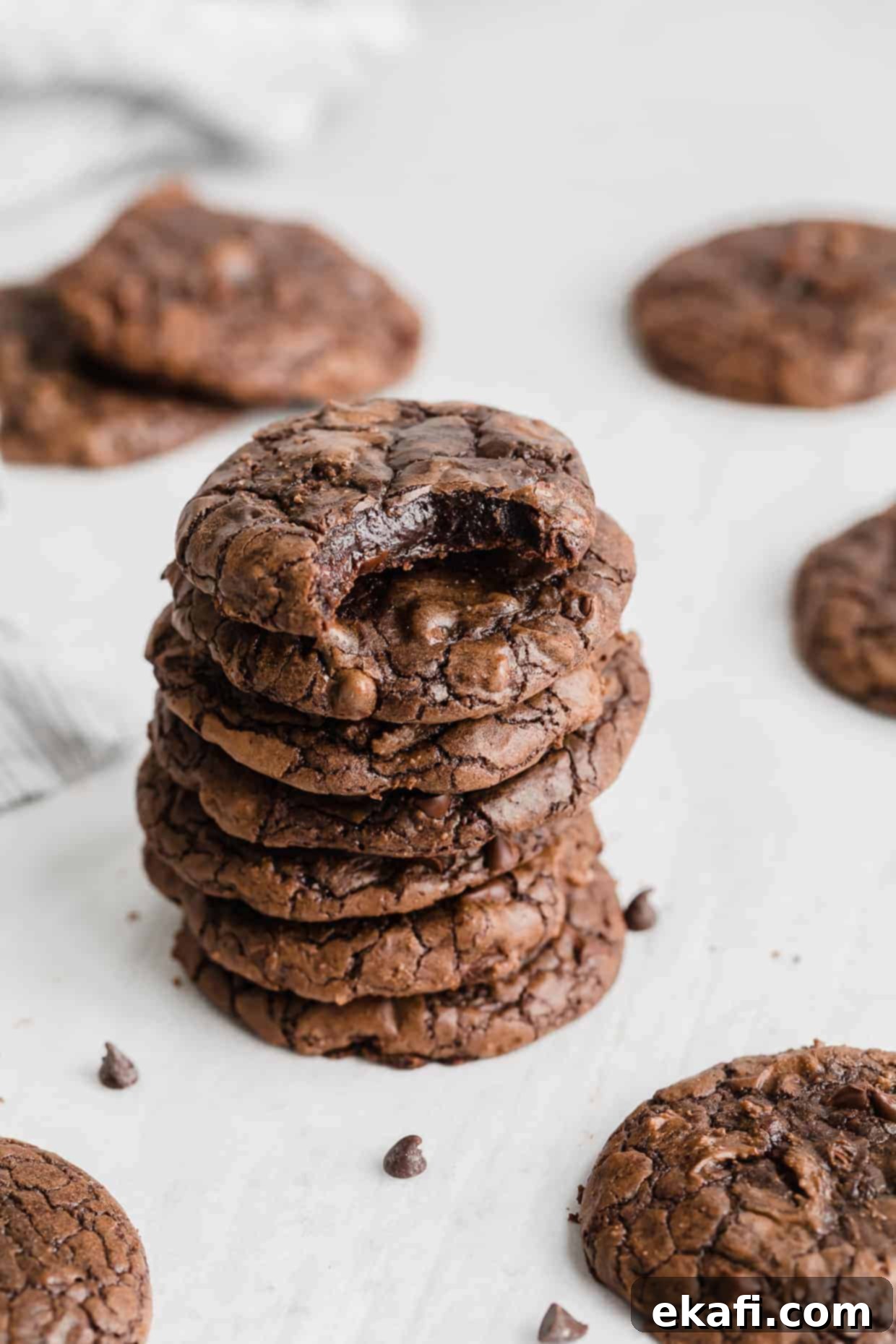 Fudgy Brownie Cookies 2 A stack of Brownie Mix Cookies against a white background with a bite taken out of the top cookie, revealing its fudgy interior.