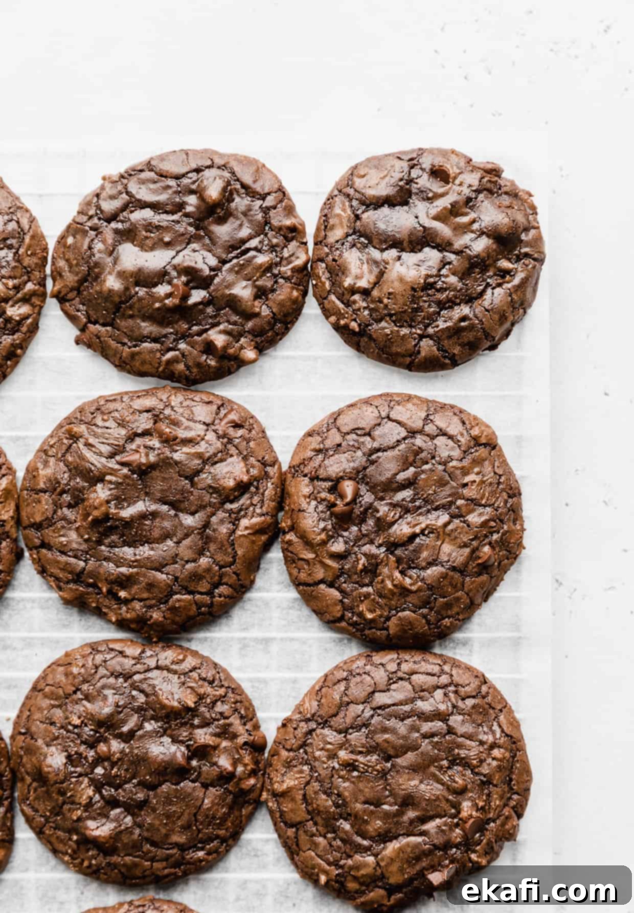 Fudgy Brownie Cookies 8 Close-up of crackly top brownie mix cookies against a white parchment background, highlighting their rich texture.