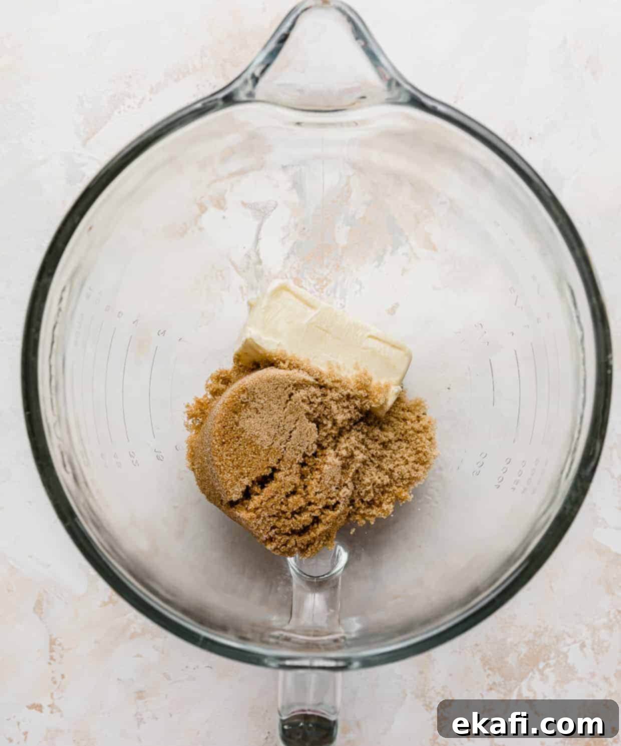 Μπισκότα Ζύμης Ben and Jerry's 5 Ένα γυάλινο μπολ ανάμιξης με ένα κομμάτι βουτύρου και καστανή ζάχαρη μέσα.