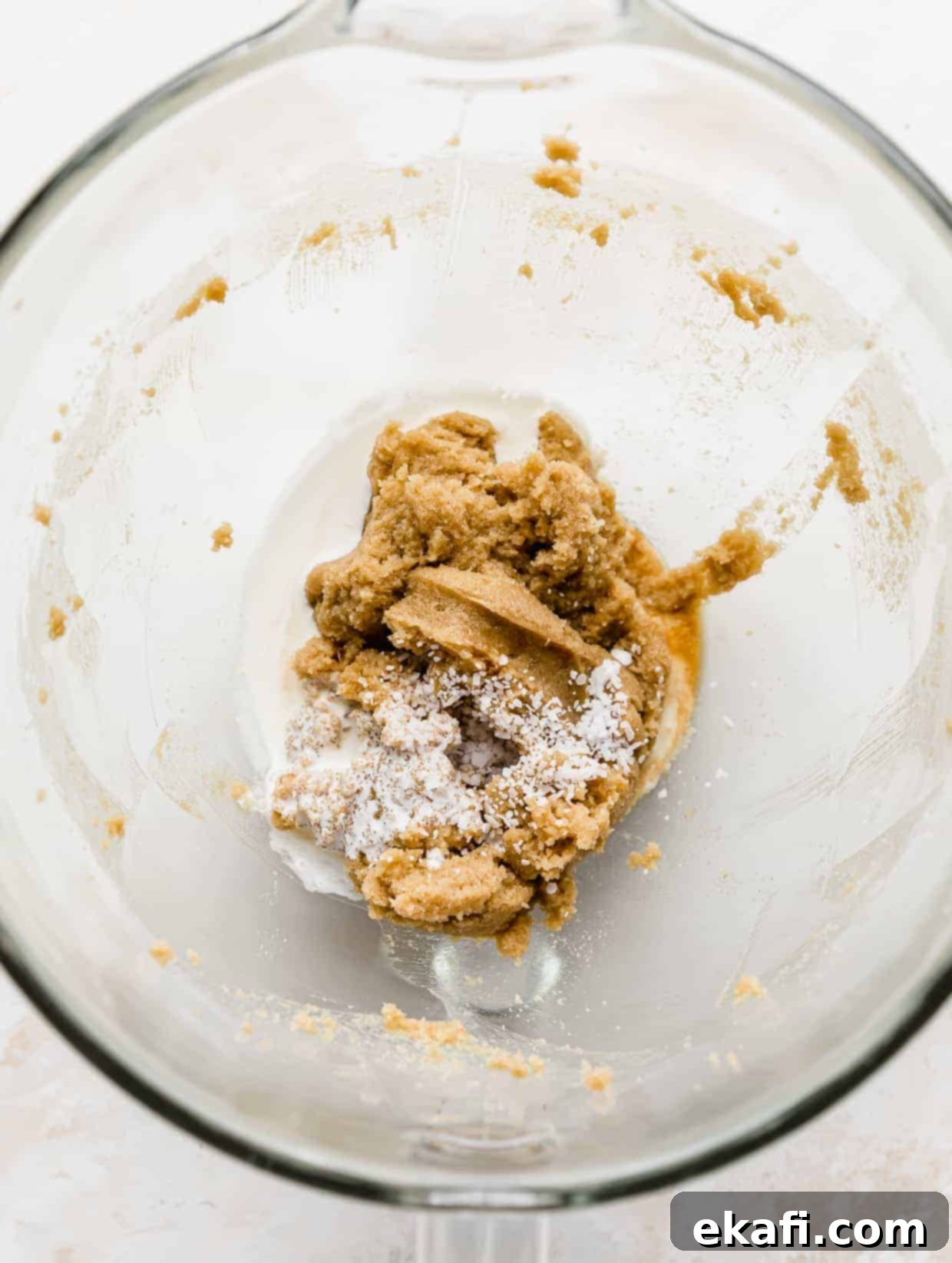 Μπισκότα Ζύμης Ben and Jerry's 6 Χτυπημένο βούτυρο και ζάχαρη σε ένα γυάλινο μπολ με αλάτι, βανίλια και κρέμα γάλακτος προστιθέμενα από πάνω.