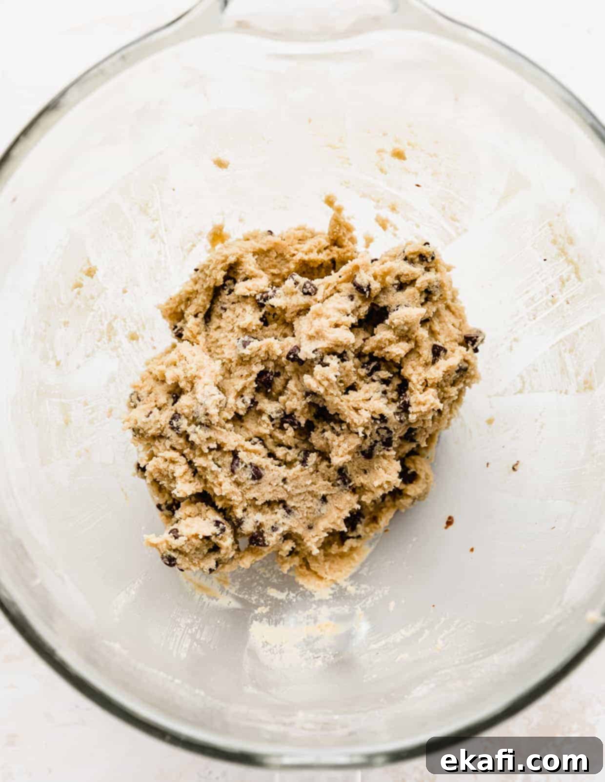 Μπισκότα Ζύμης Ben and Jerry's 10 Βρώσιμη ζύμη μπισκότου Ben and Jerry's γεμάτη με μίνι κομματάκια σοκολάτας, σε ένα γυάλινο μπολ με φόντο λευκό.