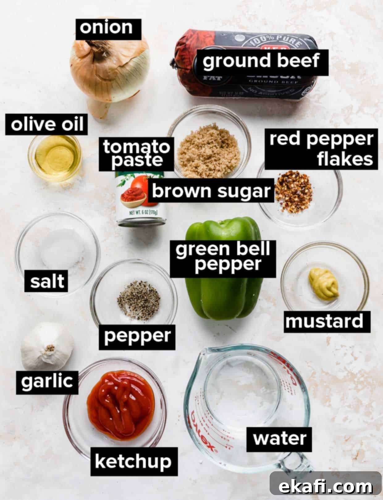 Hearty Old School Sloppy Joes 3 A colorful flat lay photograph of all the fresh ingredients used to make homemade sloppy joes, including ground beef, bell pepper, onion, garlic, tomato paste, ketchup, brown sugar, mustard, and Worcestershire sauce.