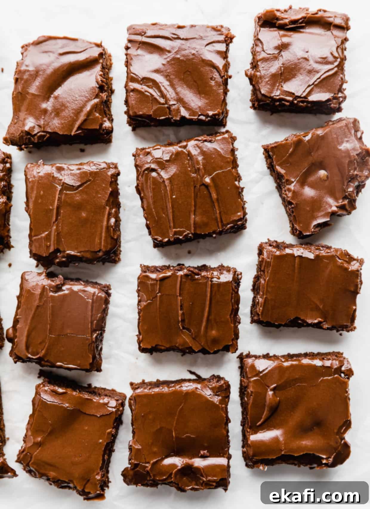 School Cafeteria Brownies 11 Perfectly cut squares of chocolate frosted Lunch Lady Brownies arranged on a white background, highlighting their uniform size and appealing texture.