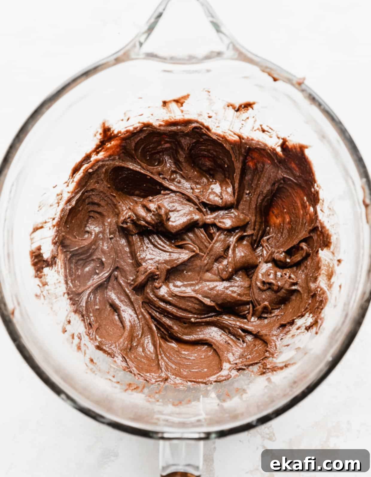 School Cafeteria Brownies 6 A glass mixing bowl full of rich chocolate lunch lady brownie batter, perfectly smooth and ready for baking, against a clean white background.