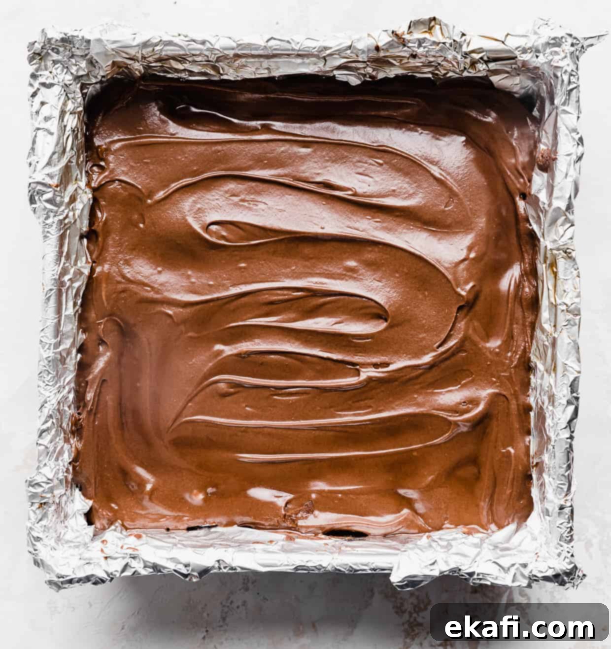 School Cafeteria Brownies 10 A pan of freshly frosted lunch lady brownies, cut into neat squares and ready to be served, set against a pristine white background.