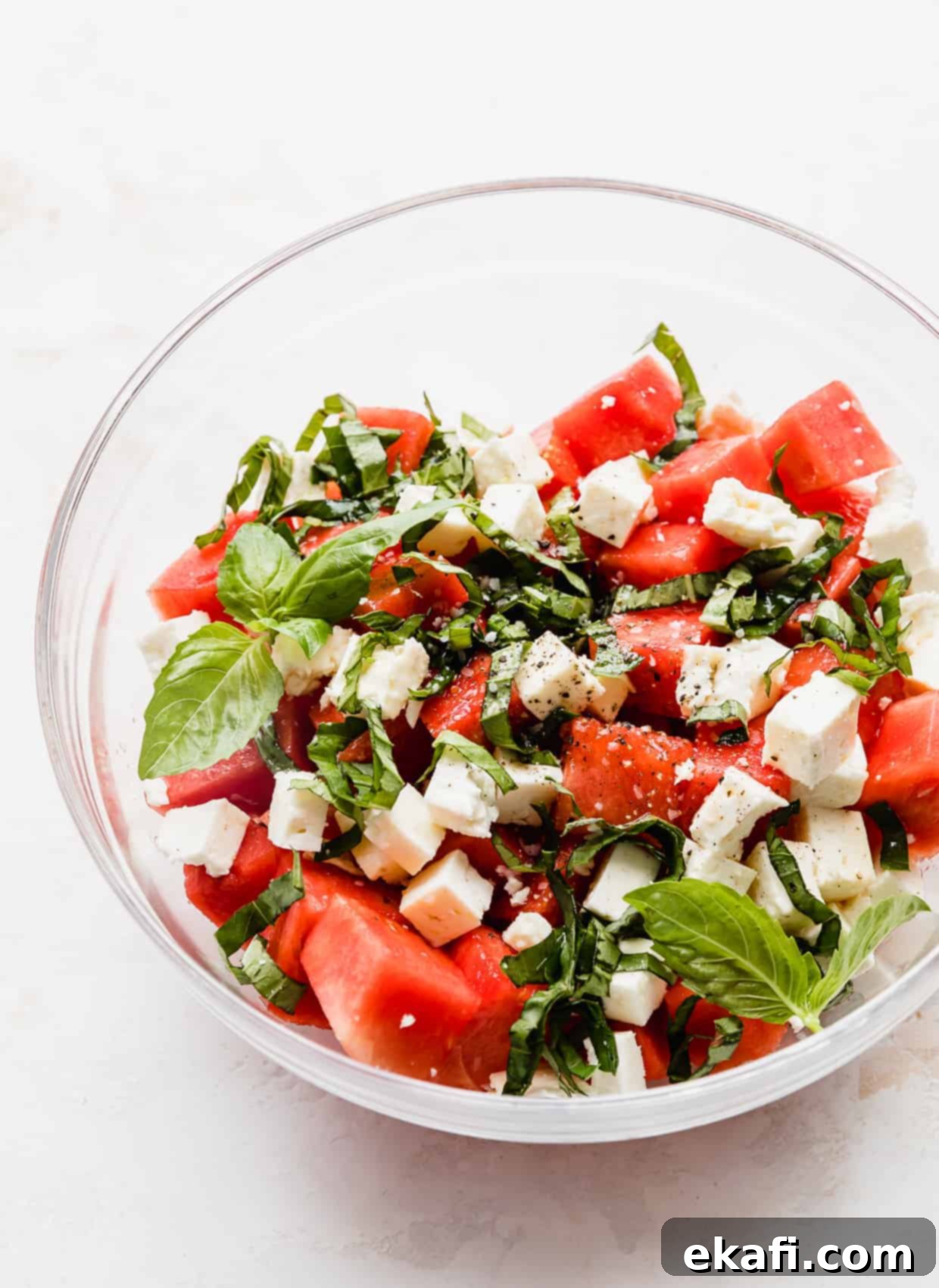 Watermelon Feta Basil Harmony 5 A complete Watermelon Feta Basil Salad in a glass bowl, showcased against a clean white background.