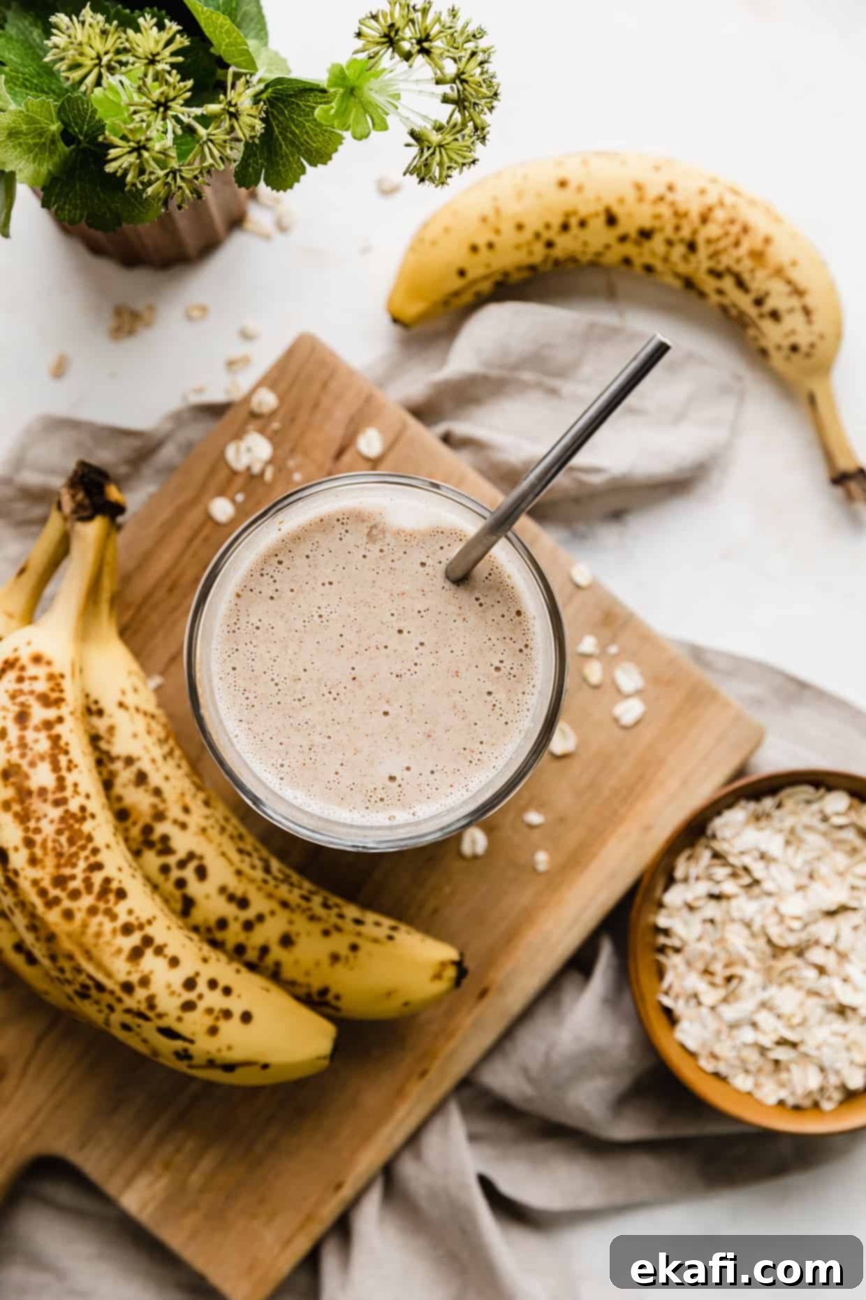Σμούθι Γαλουχίας 6 Εναέρια φωτογραφία ενός smoothie θηλασμού σε μια ξύλινη σανίδα με μπανάνες τριγύρω.