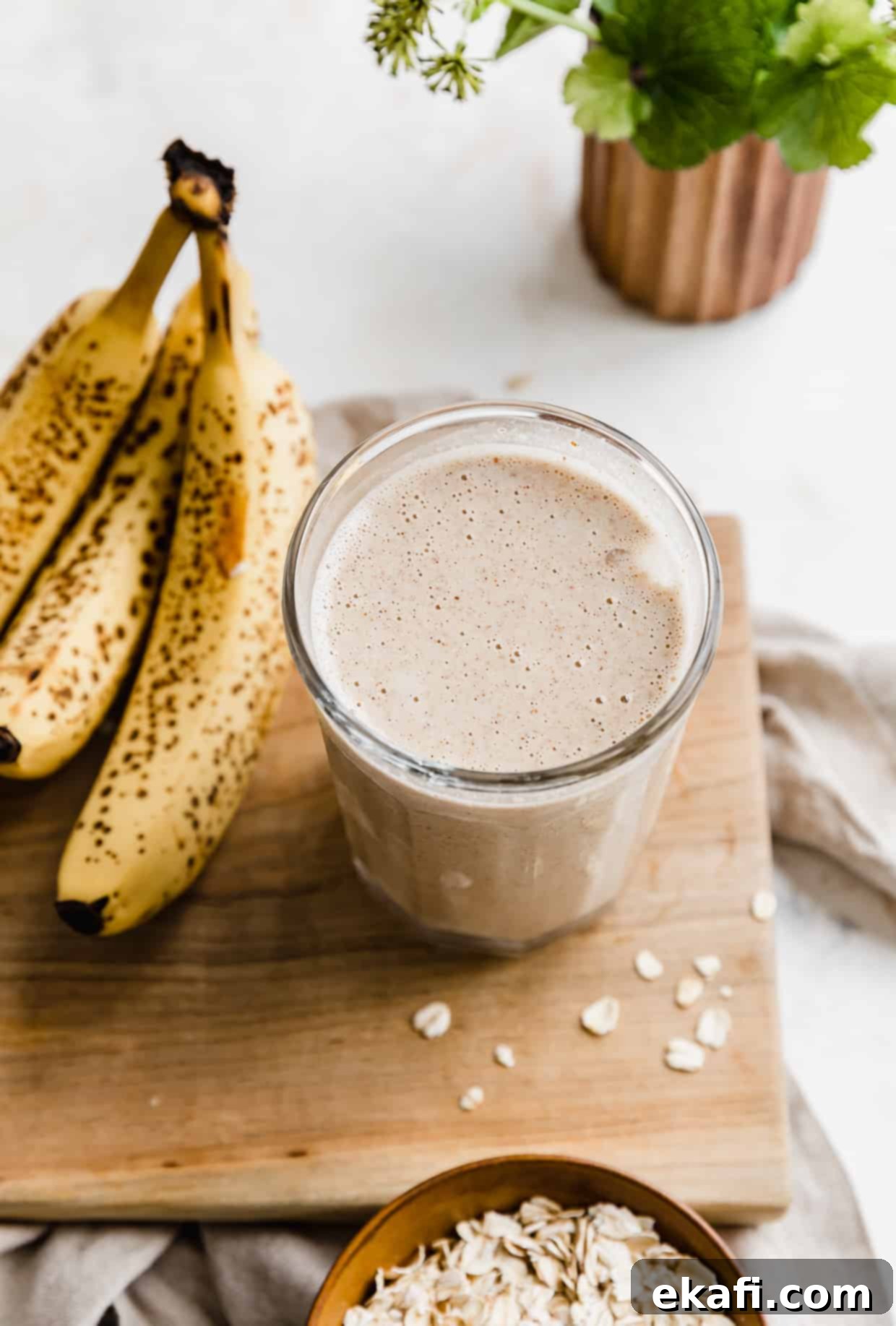 Σμούθι Γαλουχίας 7 Ένα smoothie θηλασμού σε μια ξύλινη σανίδα, με μπανάνες δίπλα στο ποτήρι.