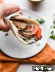 Mediterranean Lamb Gyros 11 A hand holding up a greek lamb gyro in a flat bread.