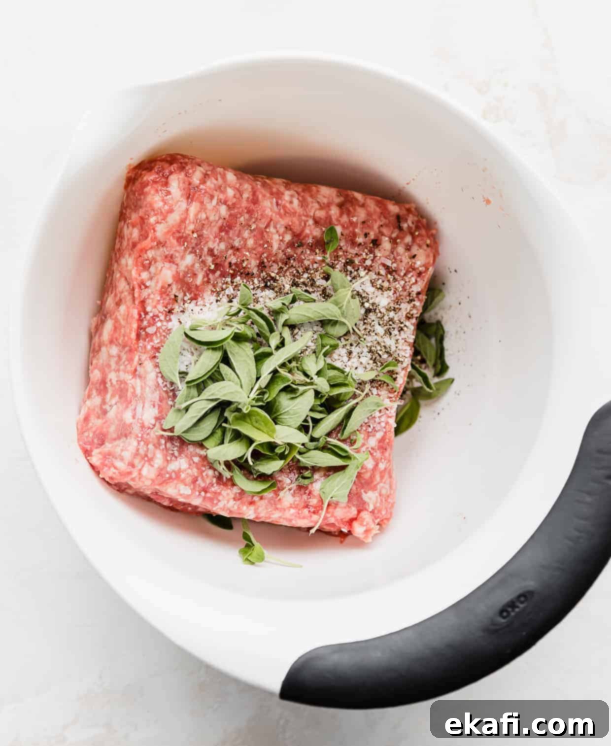 Mediterranean Lamb Gyros 3 A white bowl with ground lamb, fresh herbs and seasonings mixed together.