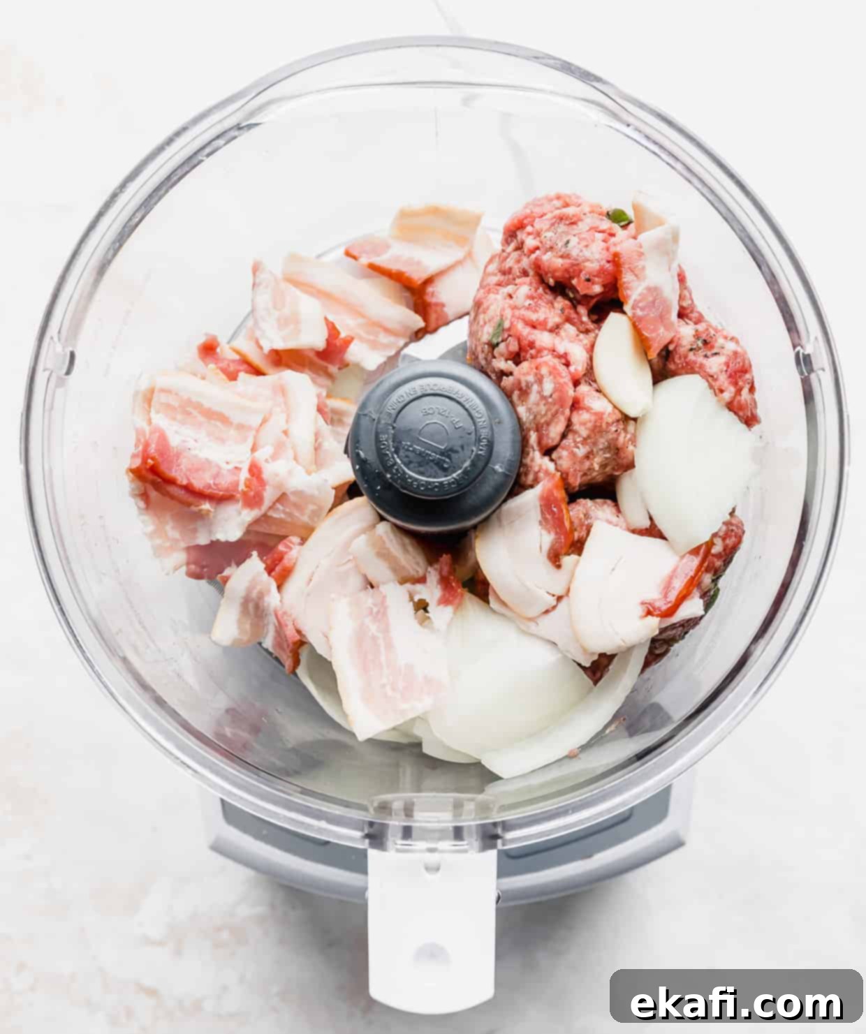 Mediterranean Lamb Gyros 4 A food processor with raw bacon, onion, and ground lamb inside, ready to be blended.