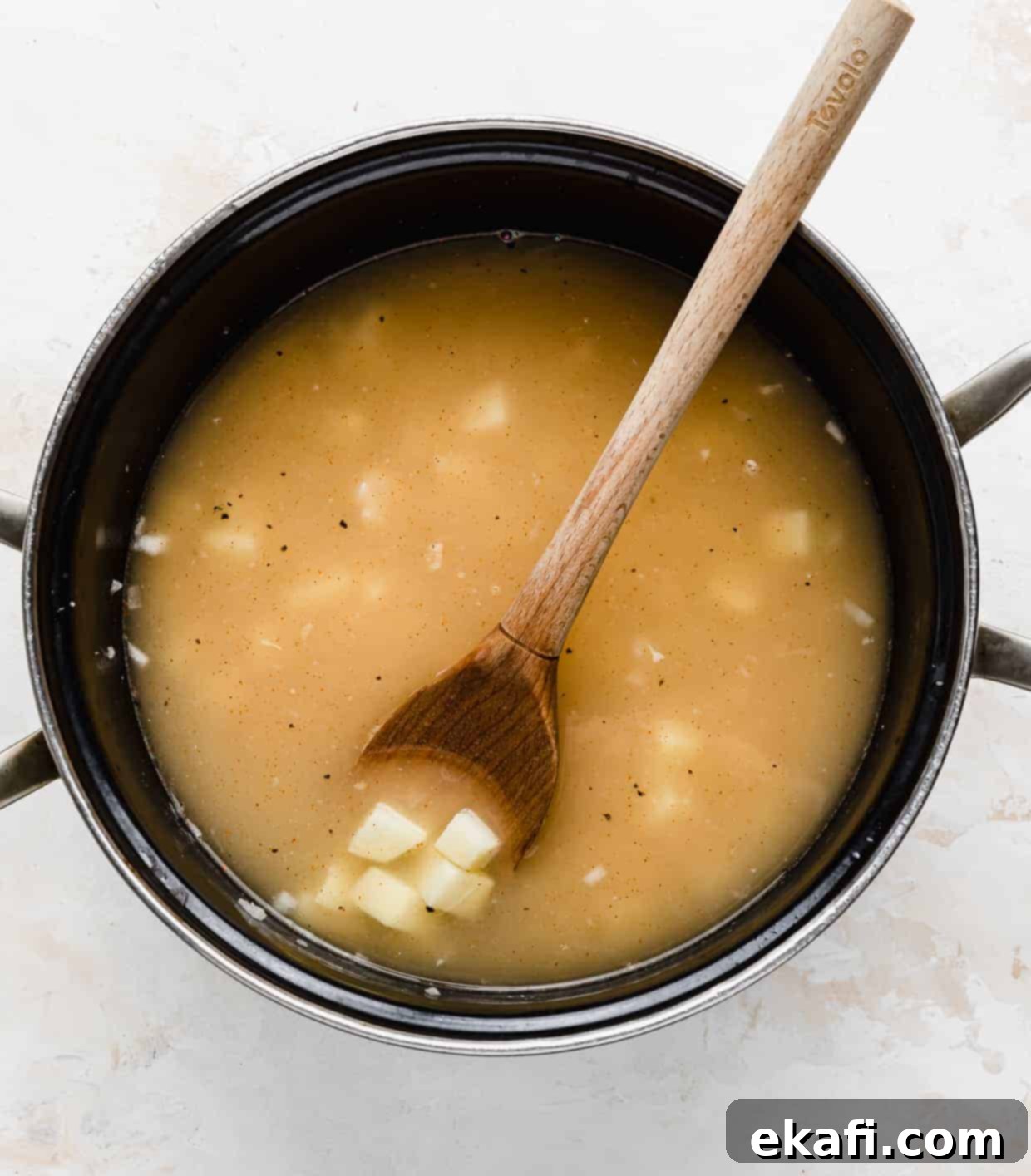 Hearty Ham and Sweet Corn Chowder 6 A pot with chicken broth and diced potatoes simmering for ham and corn chowder.