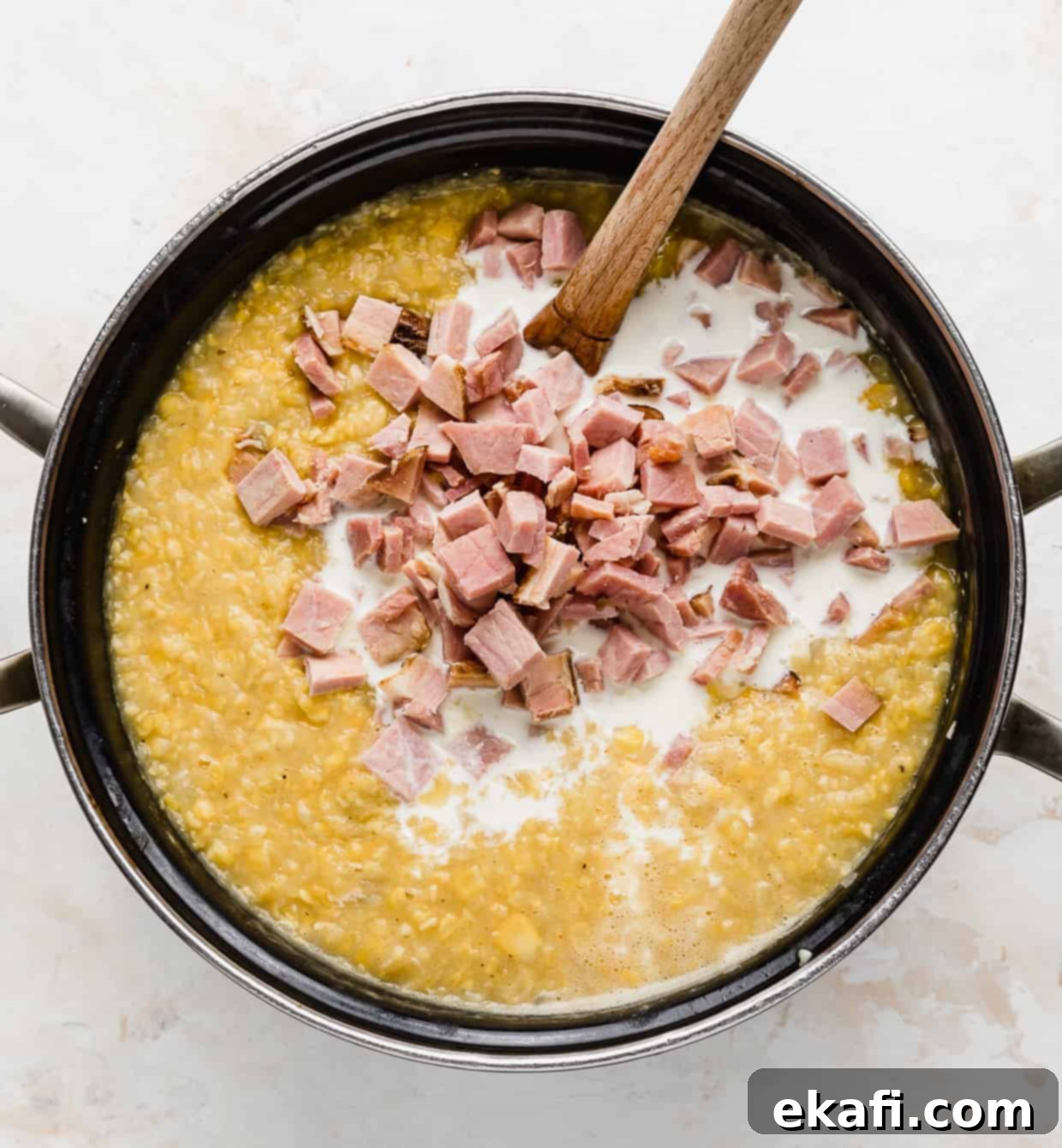 Hearty Ham and Sweet Corn Chowder 10 A large pot full of creamy corn chowder, with diced ham and heavy cream being stirred in as the final steps of preparation.
