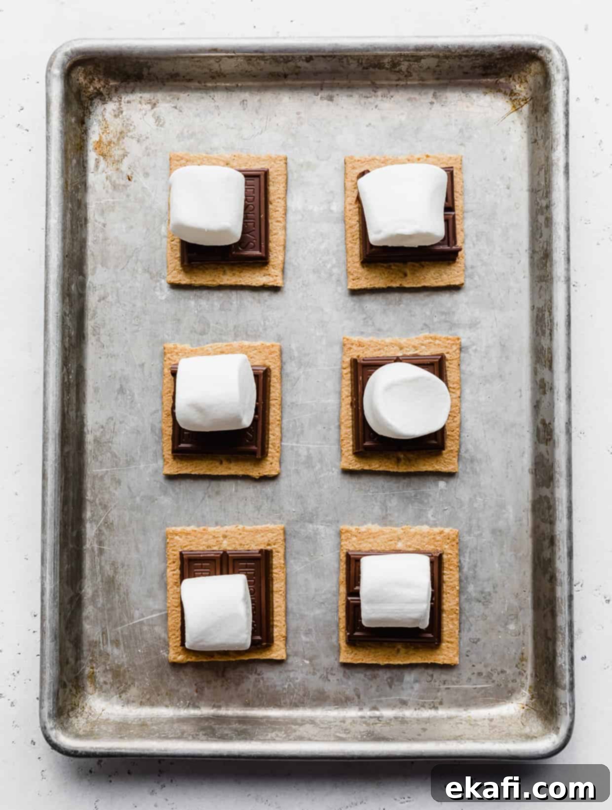 Φουρνιστά Σμορς 6 Μεγάλα marshmallows πάνω από σοκολάτα και τετράγωνα μπισκότων graham.