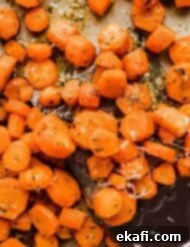 Golden Parmesan Roasted Carrots 6 Garlic Butter Roasted Carrots on a baking sheet, glistening and perfectly cooked.