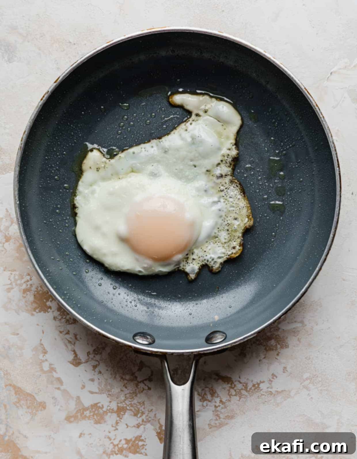 Τοστ με αβοκάντο και αυγό 7 Ένα αυγό sunny-side up σε ένα γκρι τηγάνι.