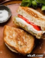 Pesto Mozzarella Sandwich 7 Pesto Mozzarella Sandwich on French bread, sliced in half with fresh tomatoes on the sandwich too.