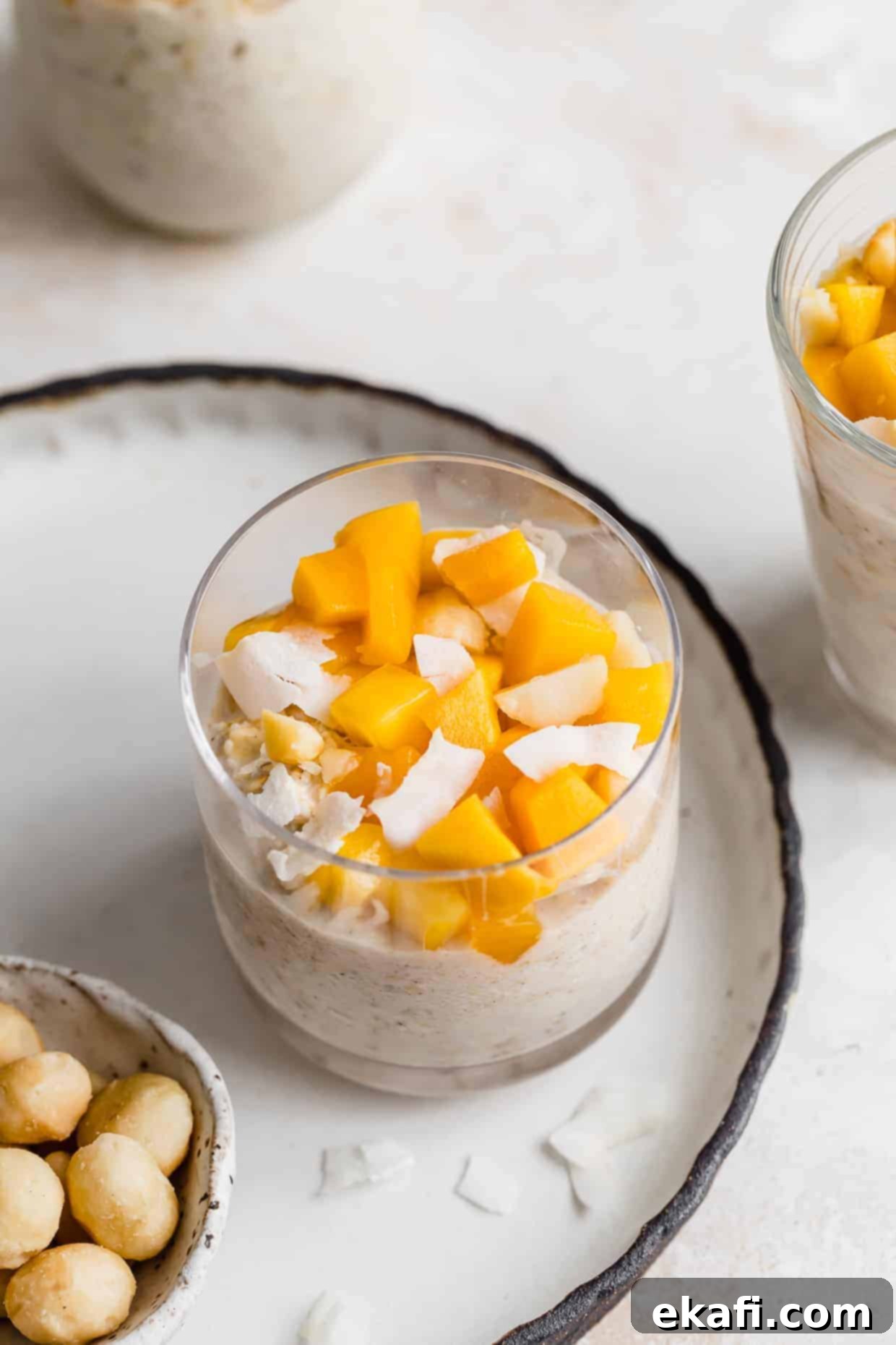 Dreamy Mango Overnight Oats 9 Diced mangos overtop of a Mango overnight oat mixture in a glass cup.
