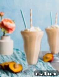 Velvet Peach Shake 8 Two glasses of peach milkshake against a blue background.
