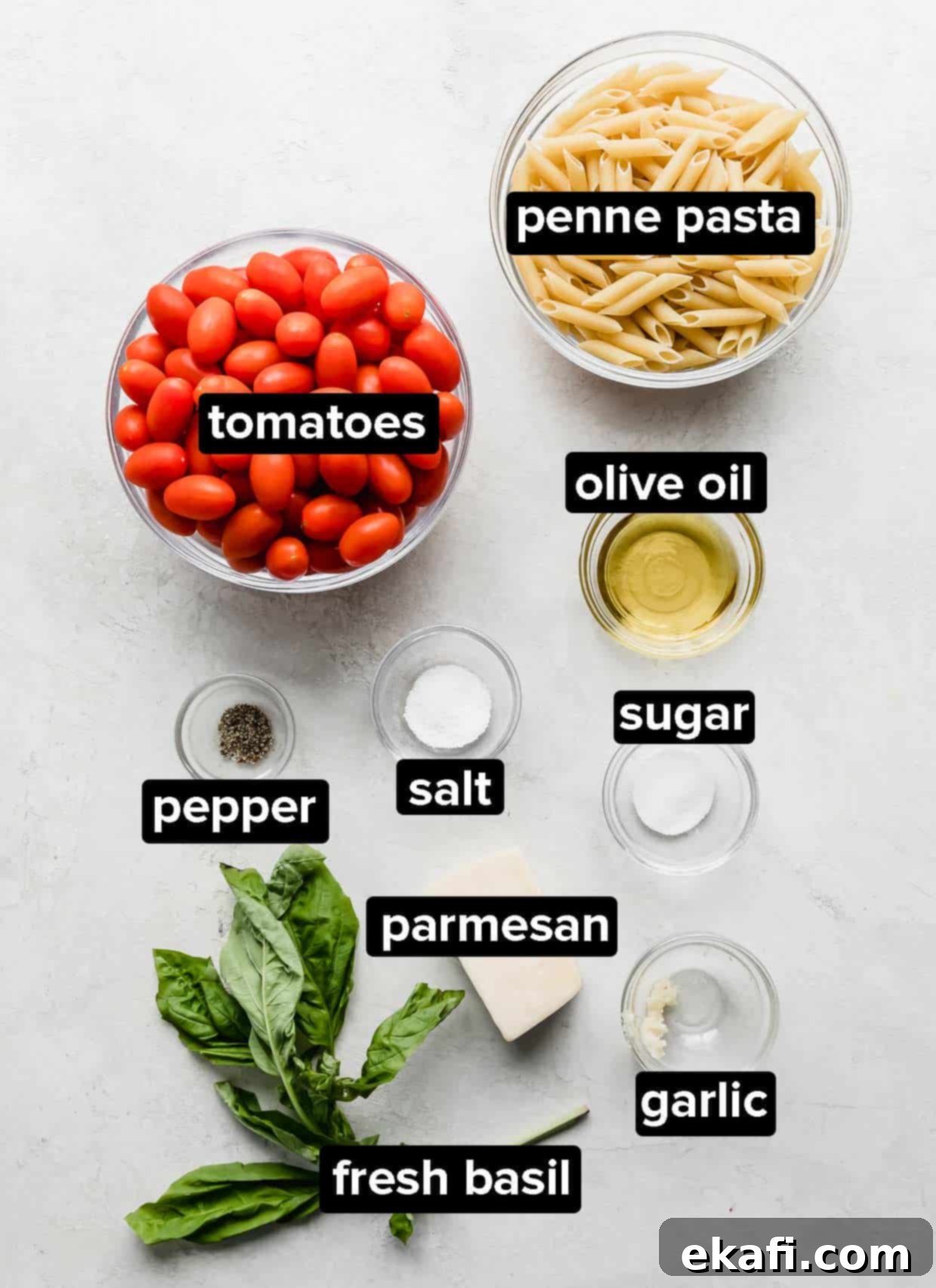 Perfect Penne Pomodoro 3 A selection of fresh ingredients including tomatoes, basil, garlic, and penne pasta arranged on a white background.