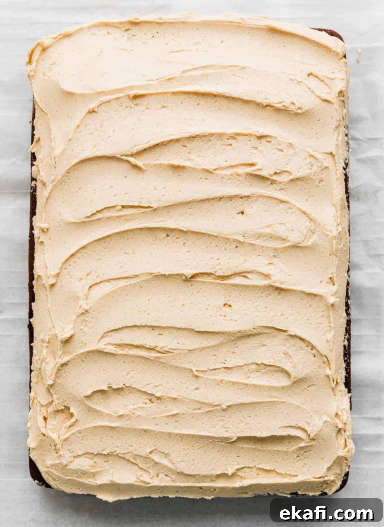 Chocolate Peanut Butter Symphony 11 A light golden colored peanut butter frosting spread smoothly and evenly across a sheet chocolate cake, creating a beautiful contrast.