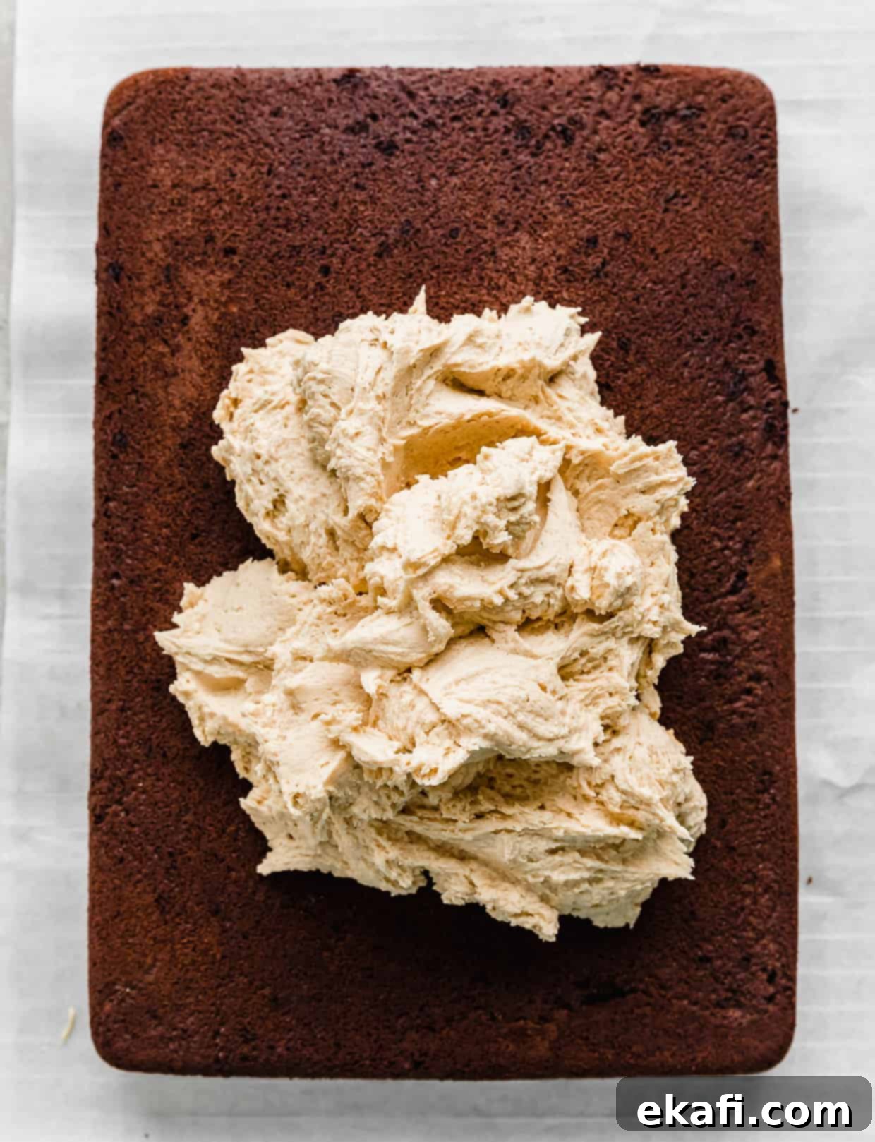 Chocolate Peanut Butter Symphony 10 A large dollop of creamy peanut butter frosting gracefully placed on a cooled chocolate cake, ready to be spread.
