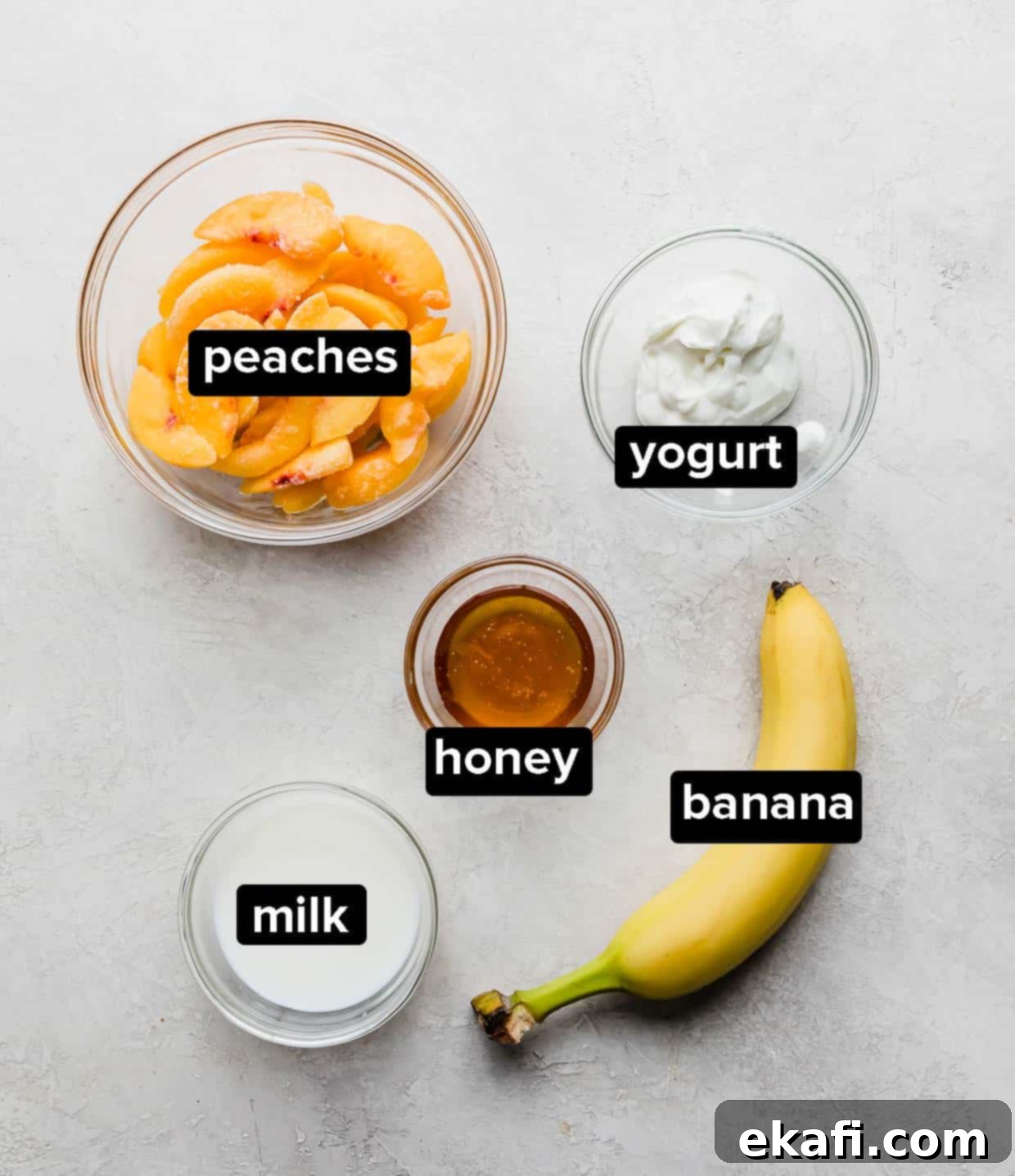 Creamy Peach Banana Bliss 4 Ingredients used to make a banana peach smoothie on a gray background.