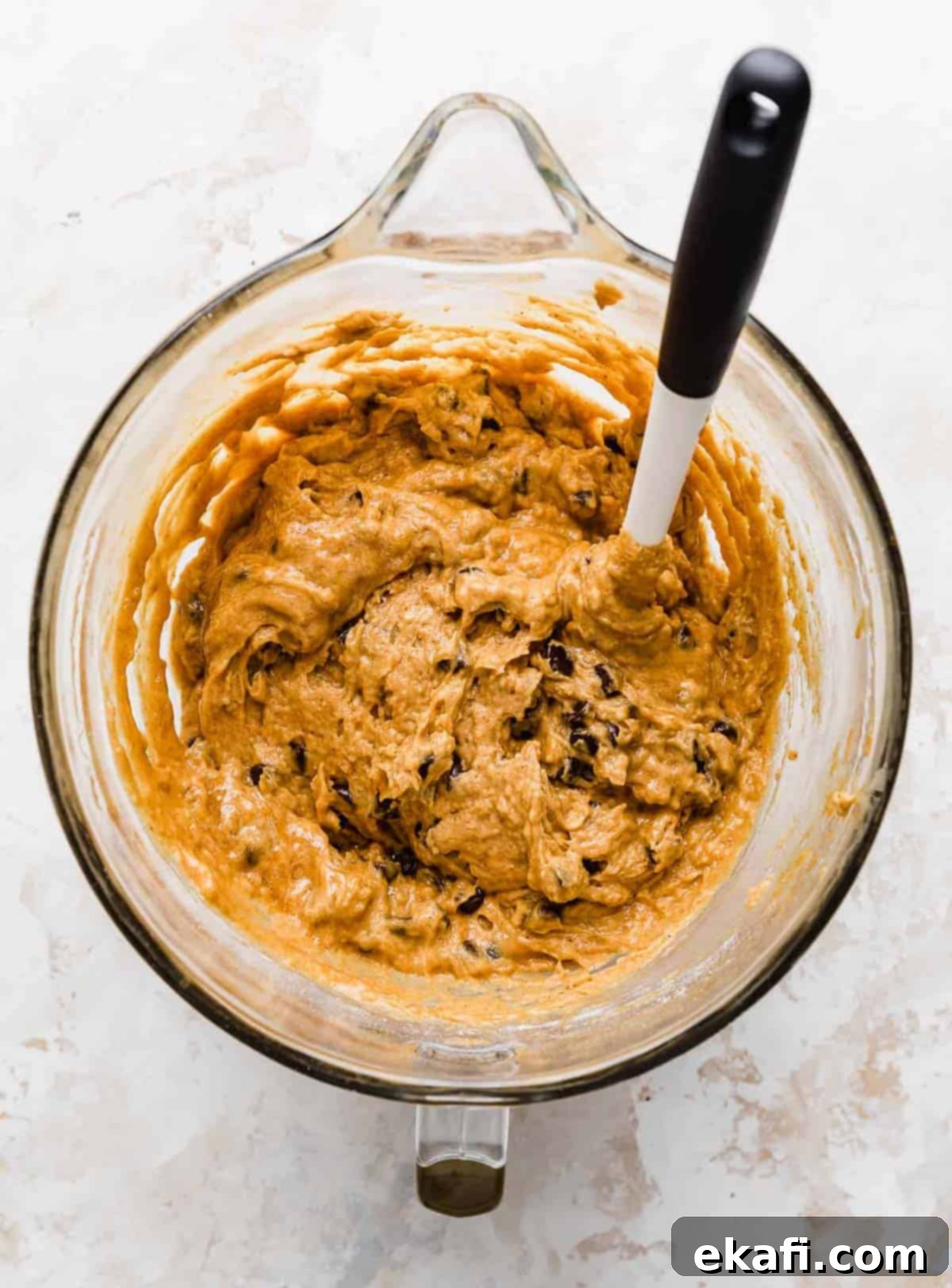Cozy Pumpkin Chocolate Chip Coffee Cake 13 Pumpkin Chocolate Chip Coffee Cake batter with a spatula in a mixing bowl.