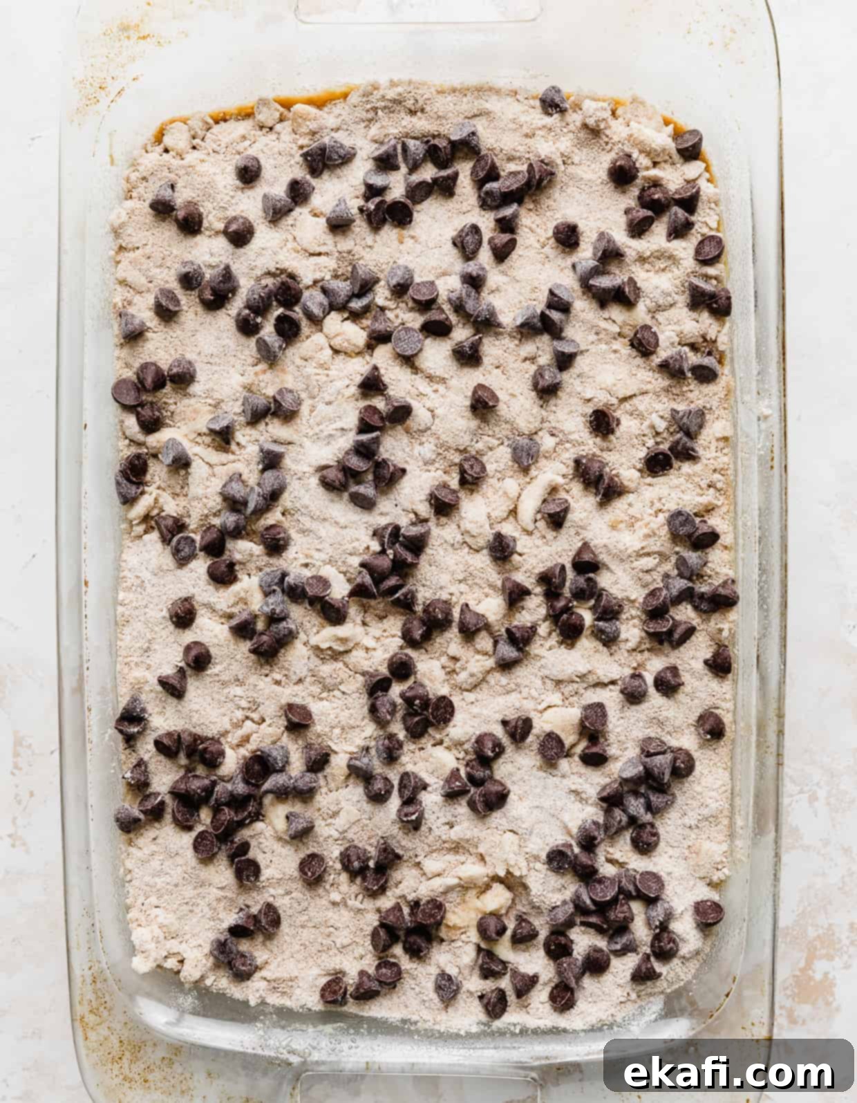 Cozy Pumpkin Chocolate Chip Coffee Cake 14 Pumpkin Chocolate Chip Coffee Cake topped with a sand colored crumble and chocolate chips in a baking dish.
