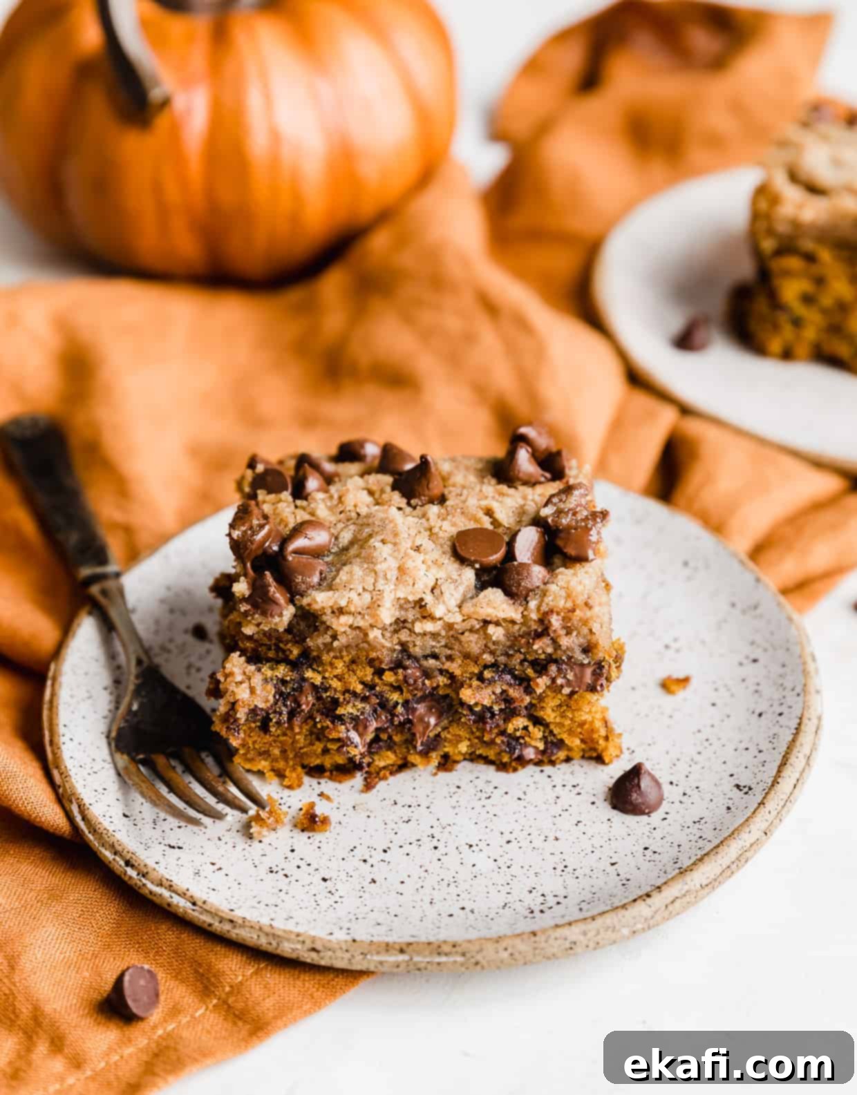 Cozy Pumpkin Chocolate Chip Coffee Cake 17 A slice of Pumpkin Chocolate Chip Coffee Cake on a white plate.