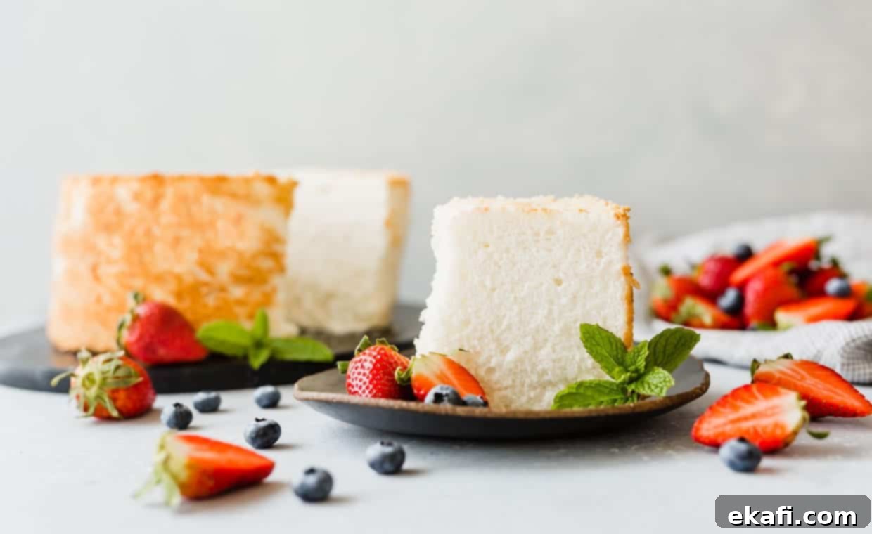 Συνταγή για Κέικ των Αγγέλων 15 Μια φέτα κέικ Angel Food σε πιάτο, με φράουλες και μύρτιλα σε όλη τη σκηνή.