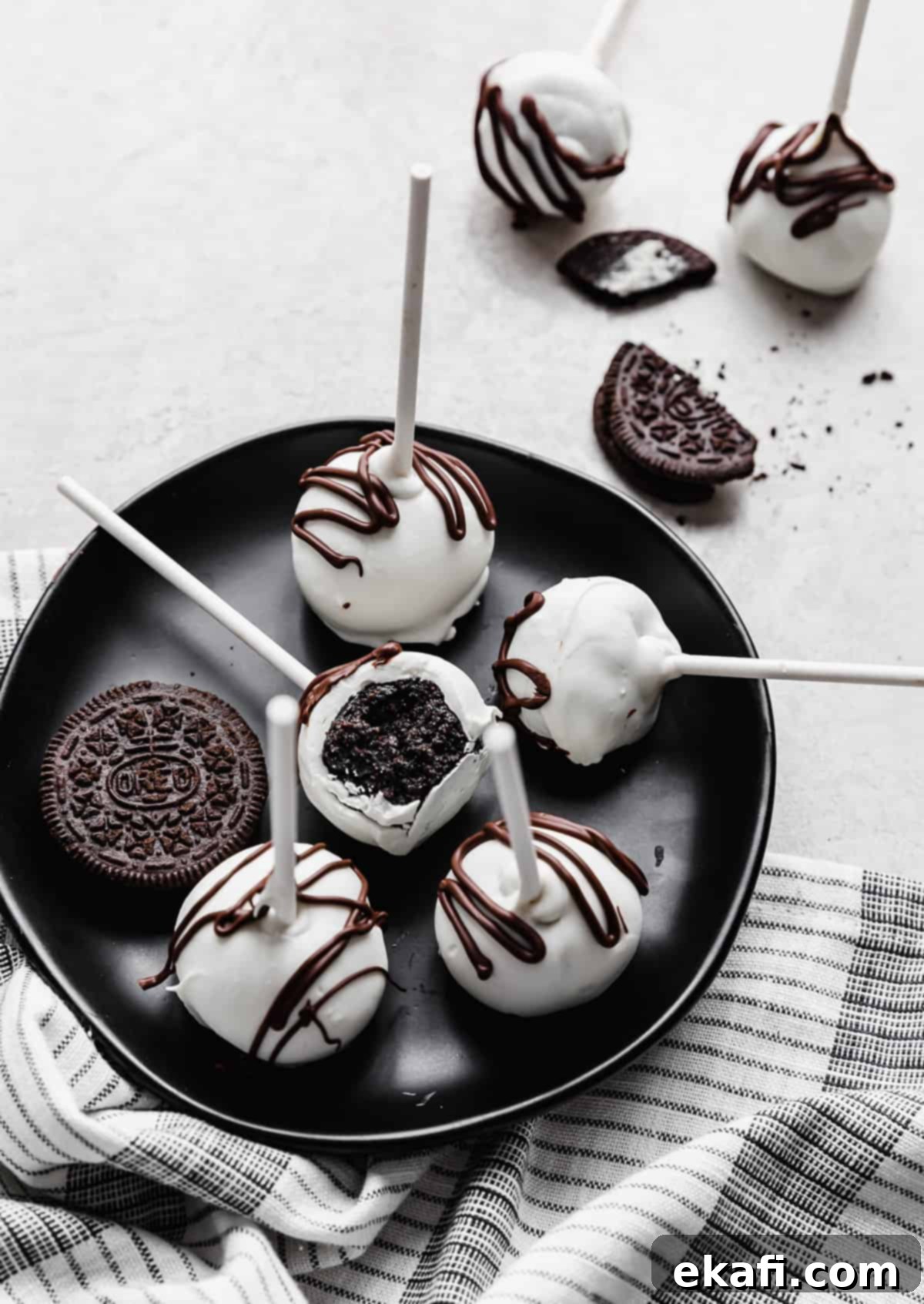 Μπουκιές Κέικ Όρεο 2 Oreo Cake Pops σε μαύρο πιάτο με ένα να έχει δαγκωθεί.
