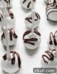 Μπουκιές Κέικ Όρεο 11 Λευκά σοκολατένια Oreo Pops με καφέ σοκολάτα περιχυμένη από πάνω.