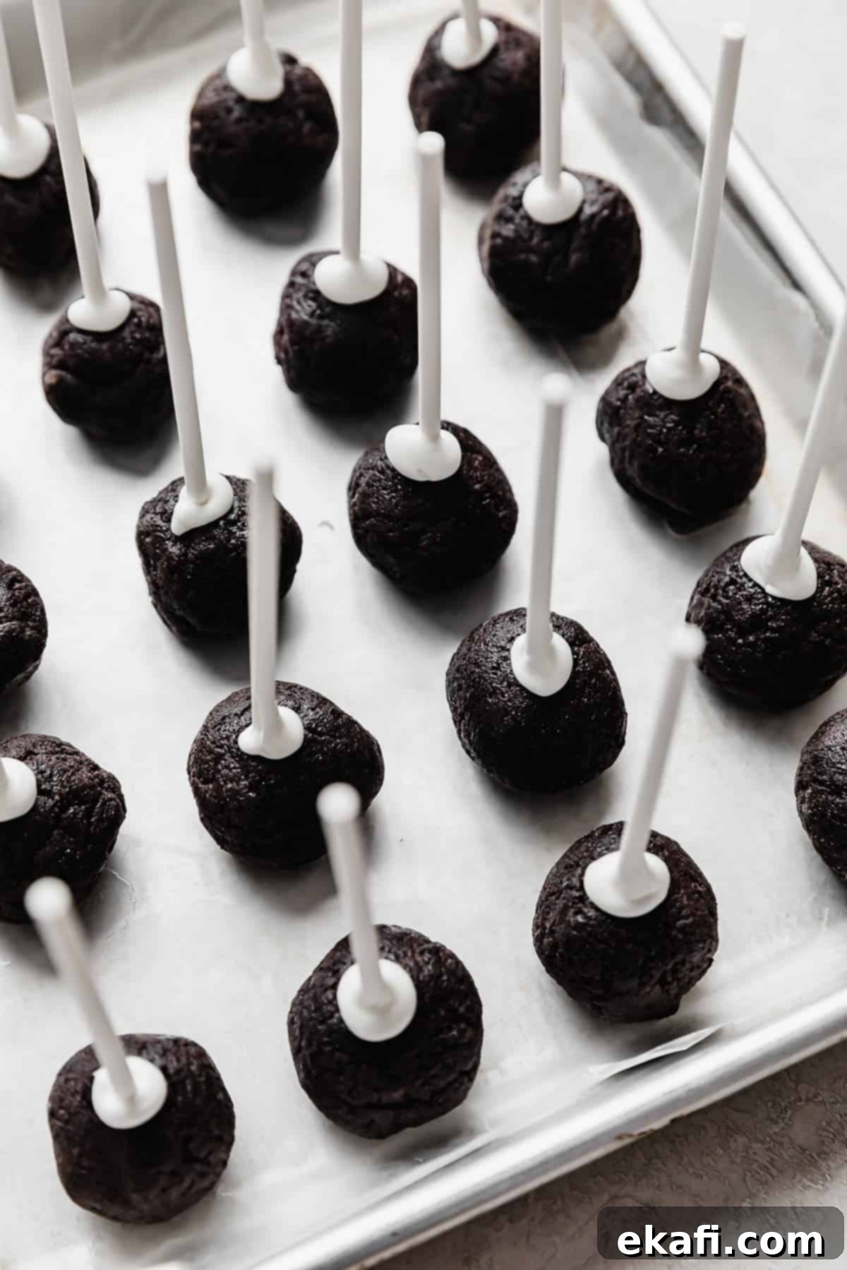 Μπουκιές Κέικ Όρεο 7 Μπαλάκια Oreo Cake Pop σε ταψί με αντικολλητικό χαρτί, με λευκά στικς γλειφιτζούρι σε κάθε Oreo pop.